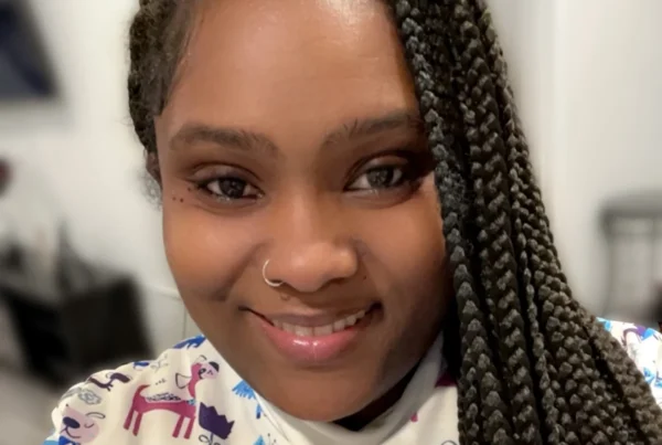 Kadian, newborn and postpartum specialist in New York, smiling at the camera.