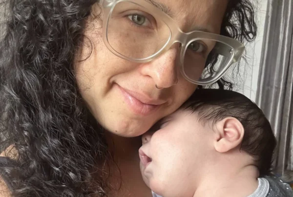Vanessa, postpartum doula holding a newborn close to her chest