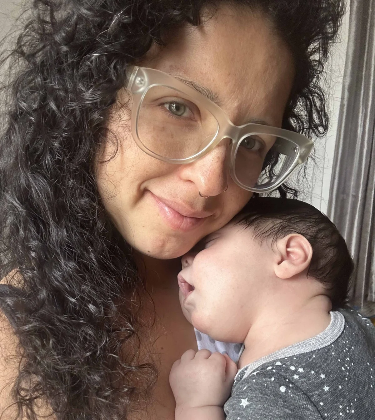 Vanessa, postpartum doula holding a newborn close to her chest