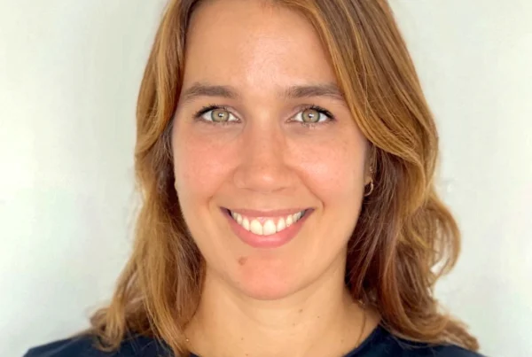 Portrait of Nina, a certified postpartum doula and yoga instructor based in New York City, smiling in a natural light setting.
